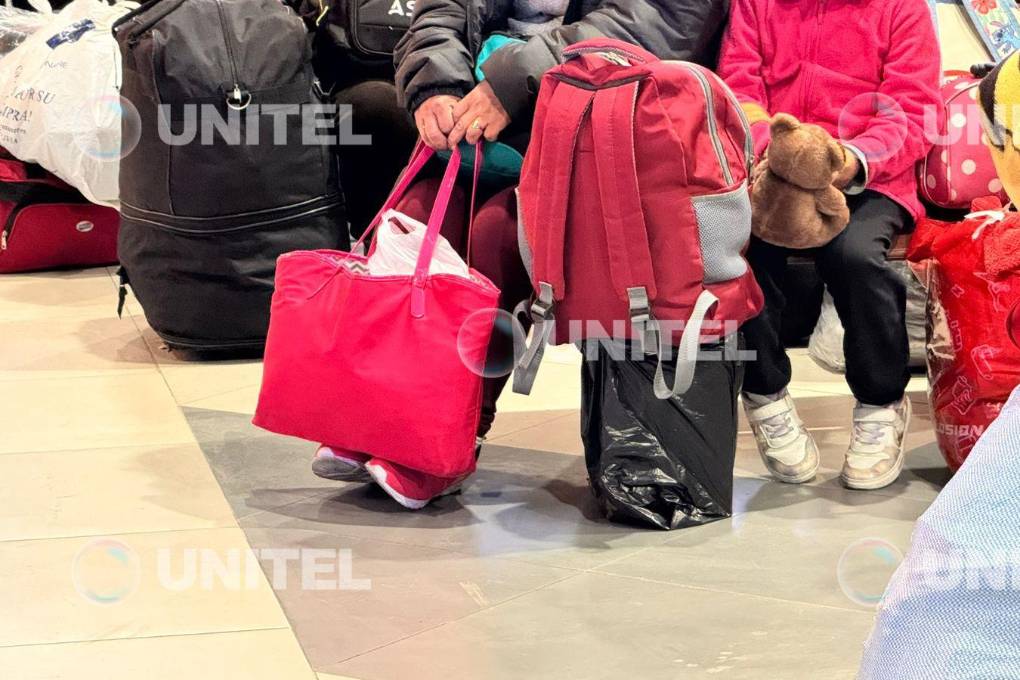 Familias con niños aguardan a la salida de buses. Familias con niños aguardan a la salida de buses.