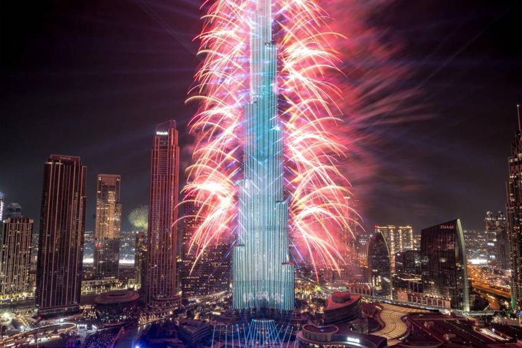 Los fuegos artificiales iluminan el cielo junto al emblemático rascacielos Burj Khalifa, el edificio más alto del mundo, en Dubai a la medianoche de la víspera de Año Nuevo del 1 de enero de 2024.