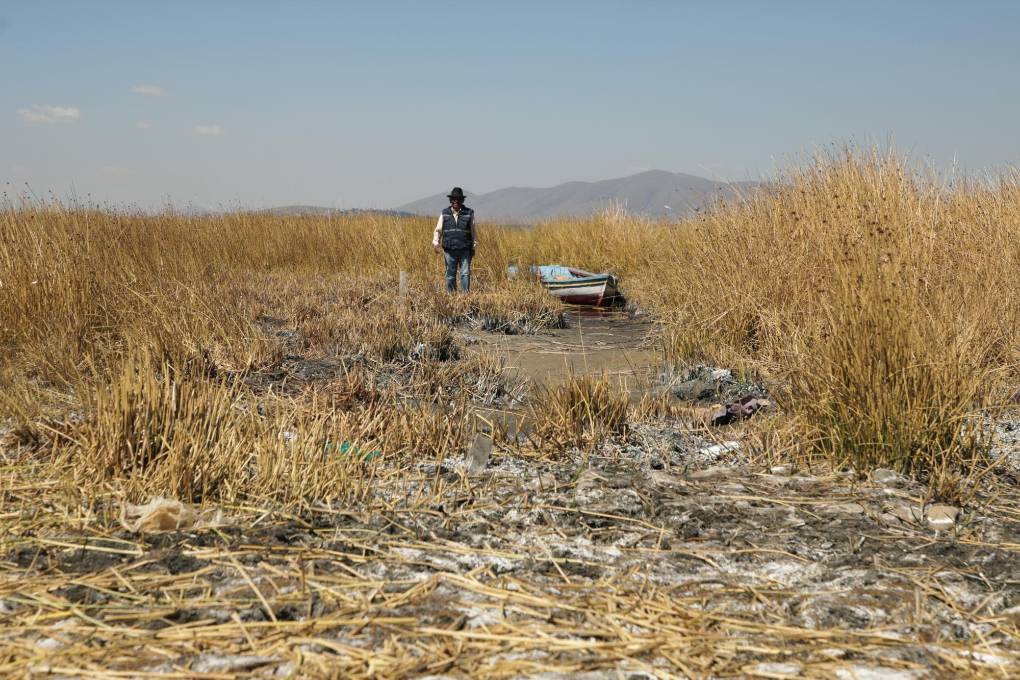 Pedro de la Cruz camina a lo largo de un área ahora seca del lago Titicaca.