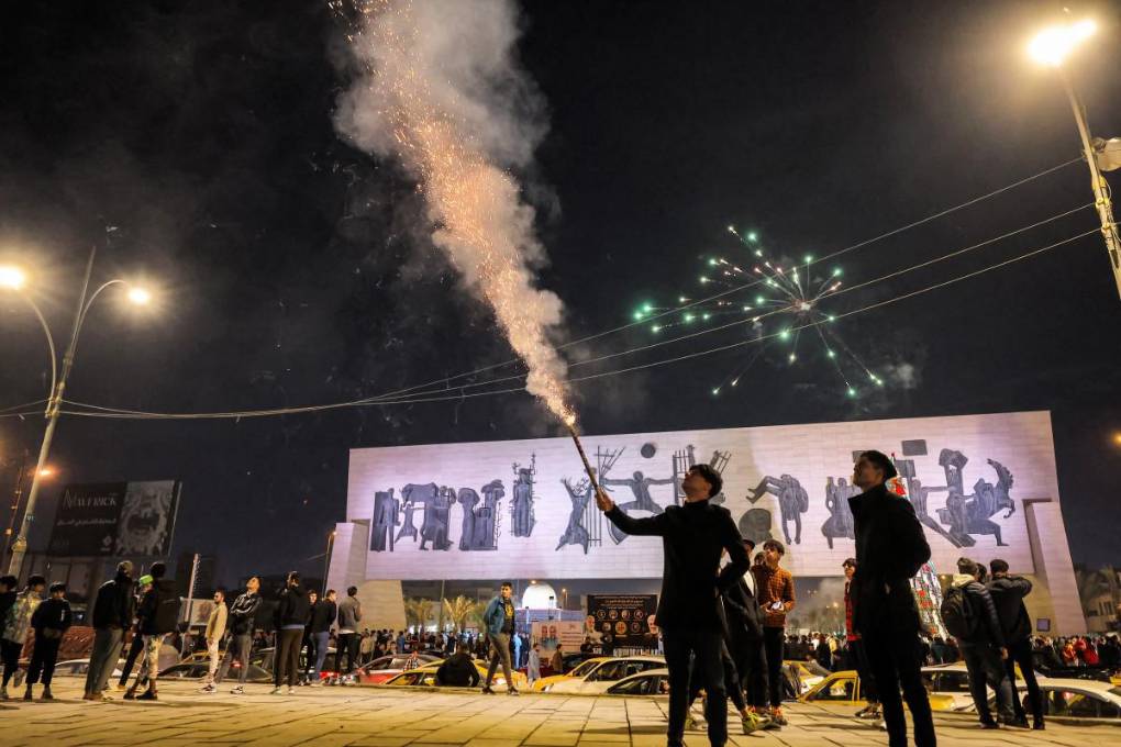 Un hombre dispara una bengala antes de la medianoche en la plaza Tahrir, en el centro de Bagdad