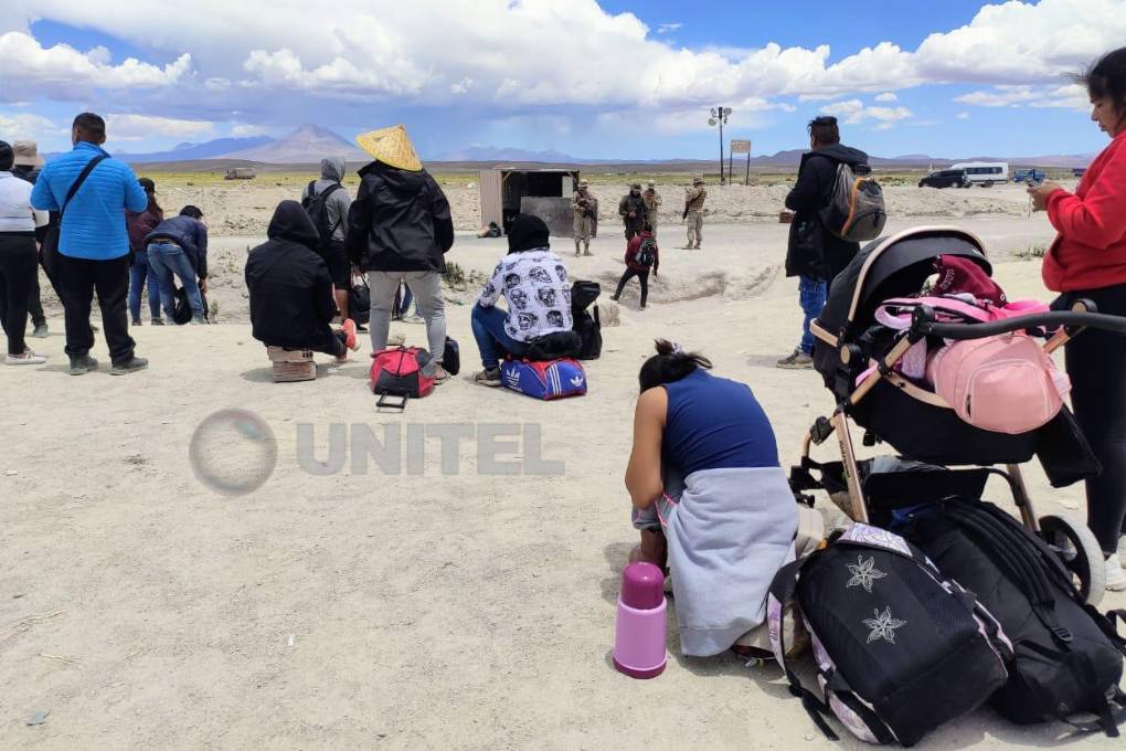 Un grupo de migrantes espera cruzar la frontera.