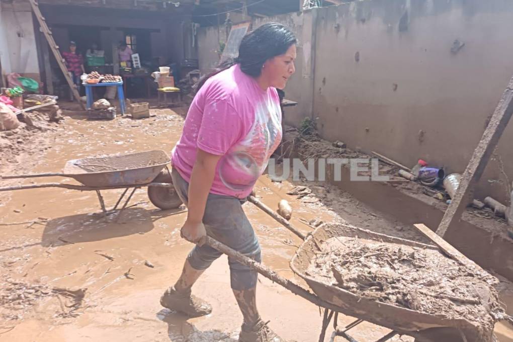 La mujer retira el lodo de su vivienda